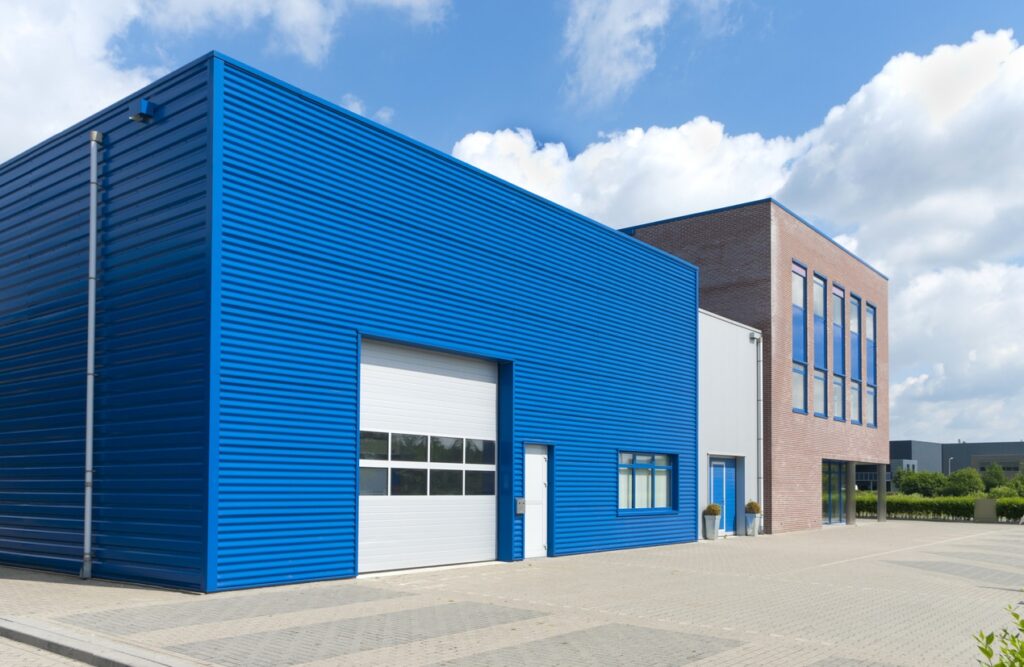 Bâtiment d'entreprise au bardage bleu avec porte sectionnelle