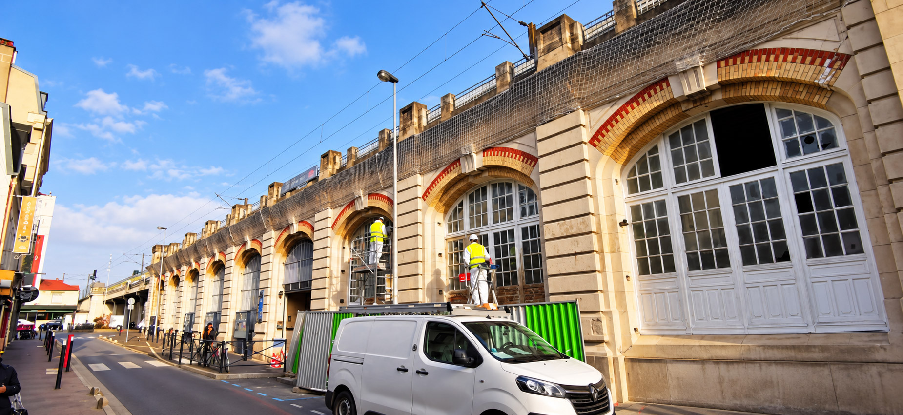 Techniciens Renkö en combinaison et gilet de sécurité devant les menuiseries de la gare SNCF du Raincy, pendant la décontamination des peintures au plomb