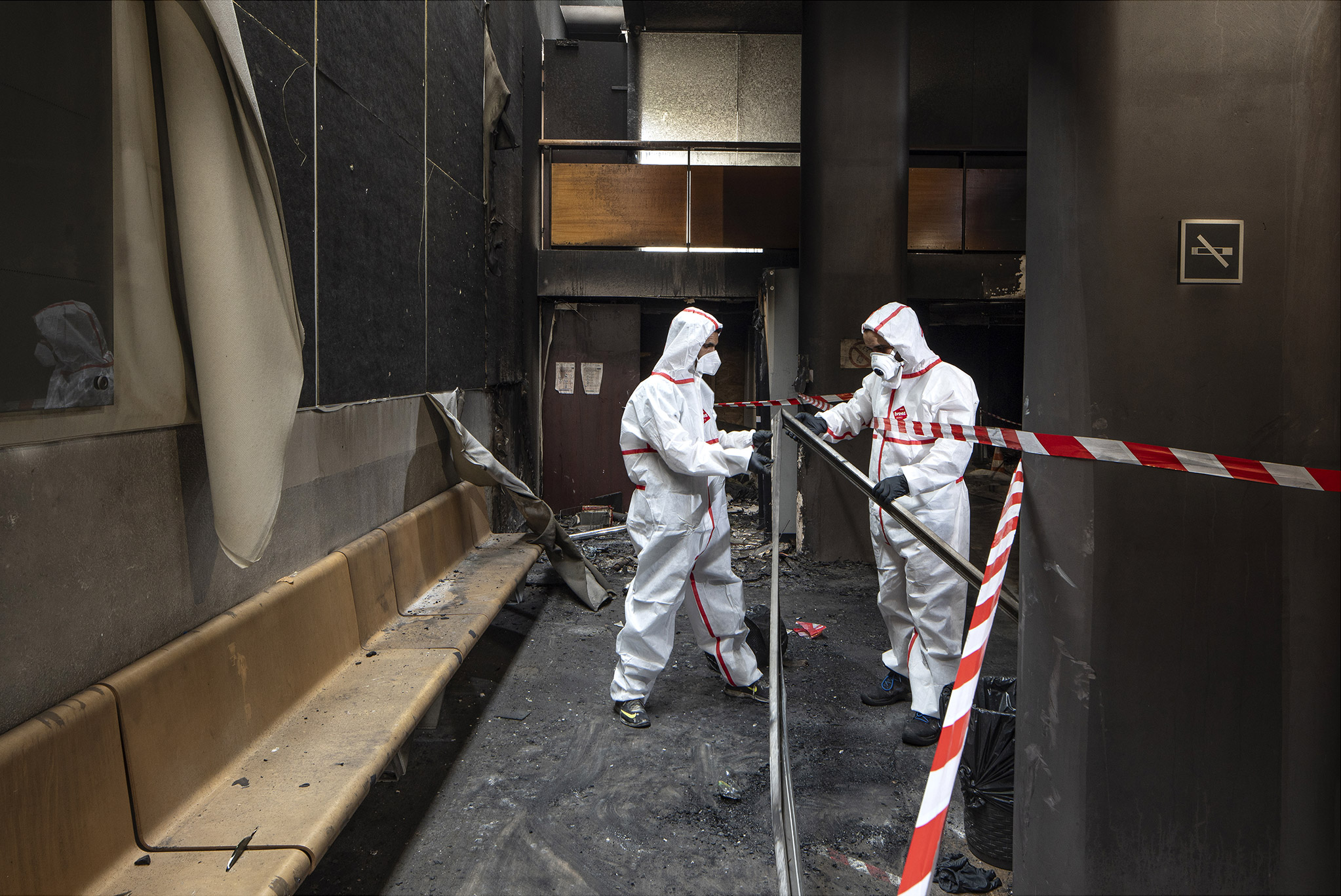 Deux techniciens Renkö en combinaison de protection dans les locaux incendiés du tribunal d’Asnières-sur-Seine, zone balisée