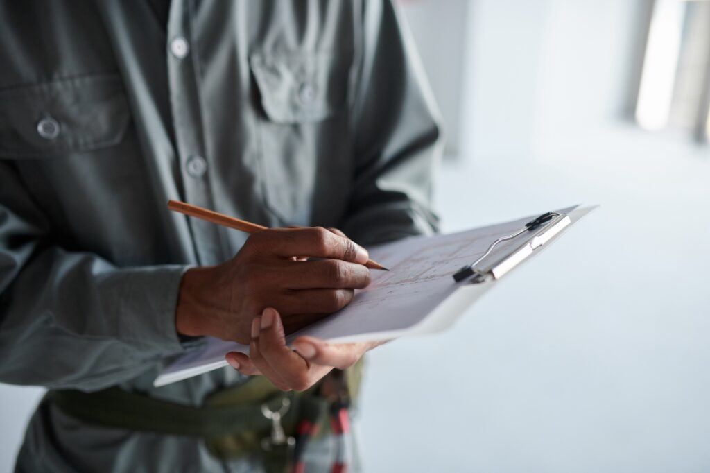 Professionnel remplissant une grille d'audit sur un porte-documents